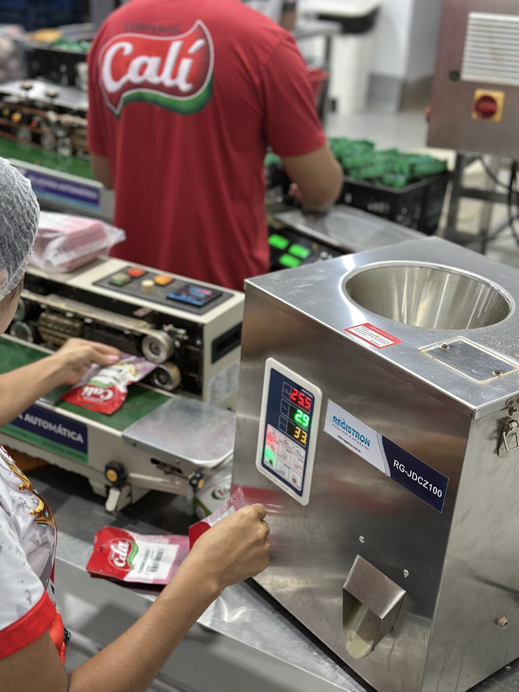 Produção da Cáli: equipe embalando sachês de tempero na linha de produção